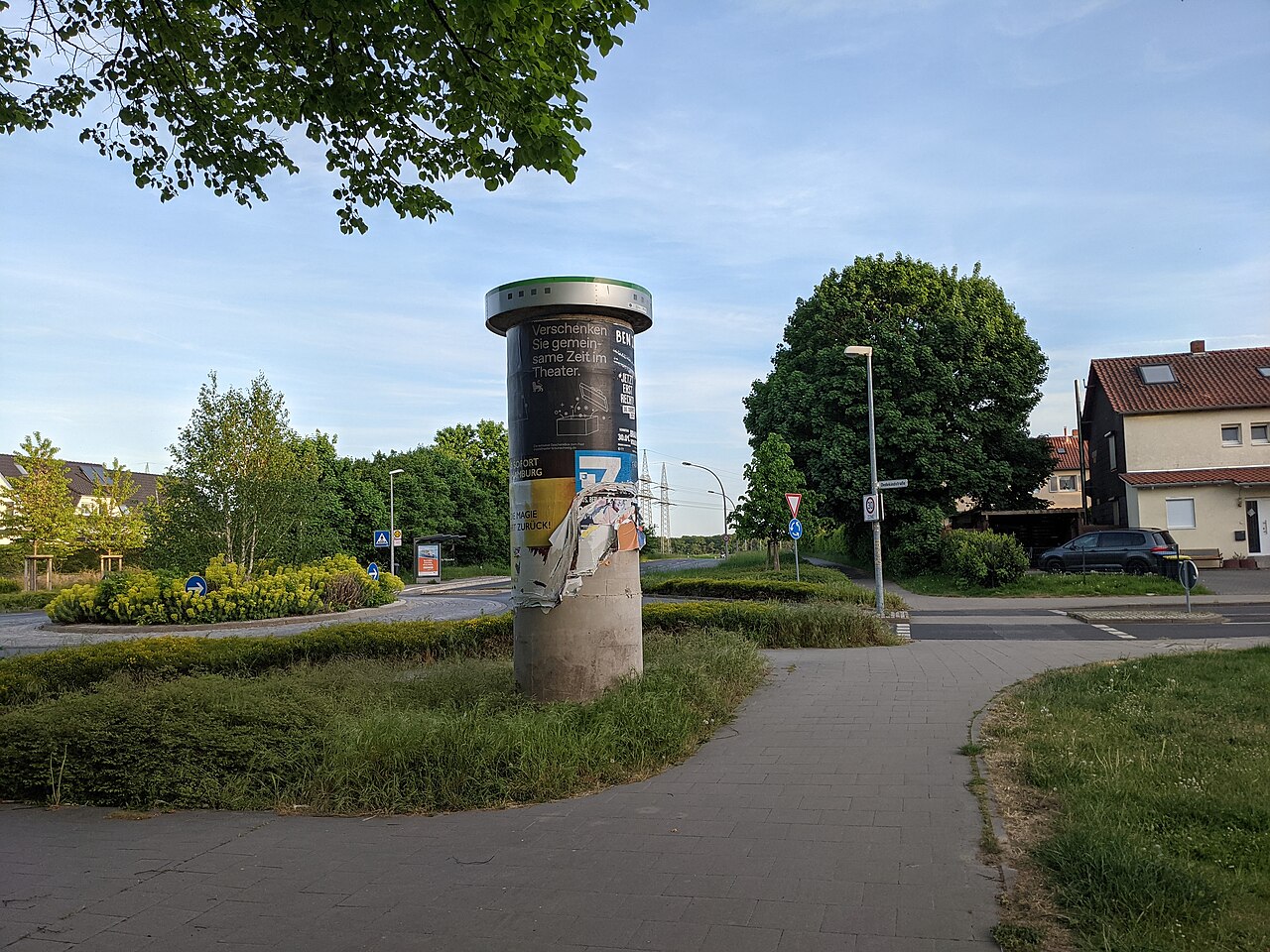An advertising column plastered with torn and overlapping posters